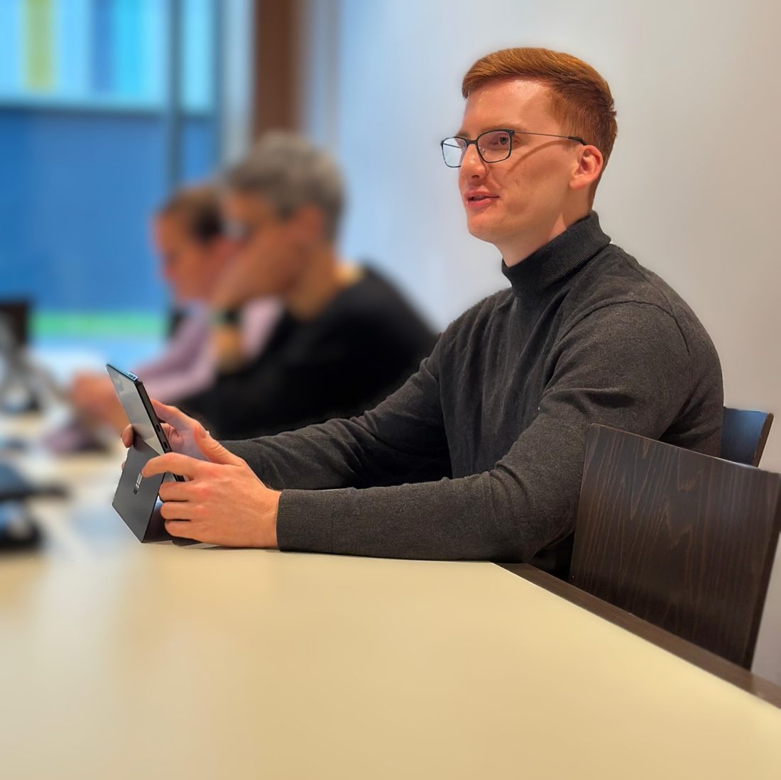 Jonas Klar im Rollkragenpullover am Sitzungstisch